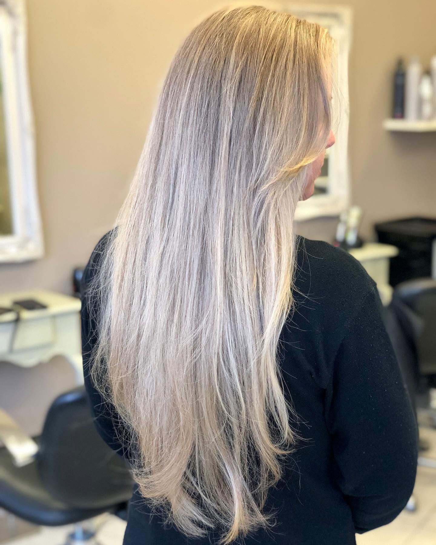 Long, silvery ash blonde hair seen from behind in the salon